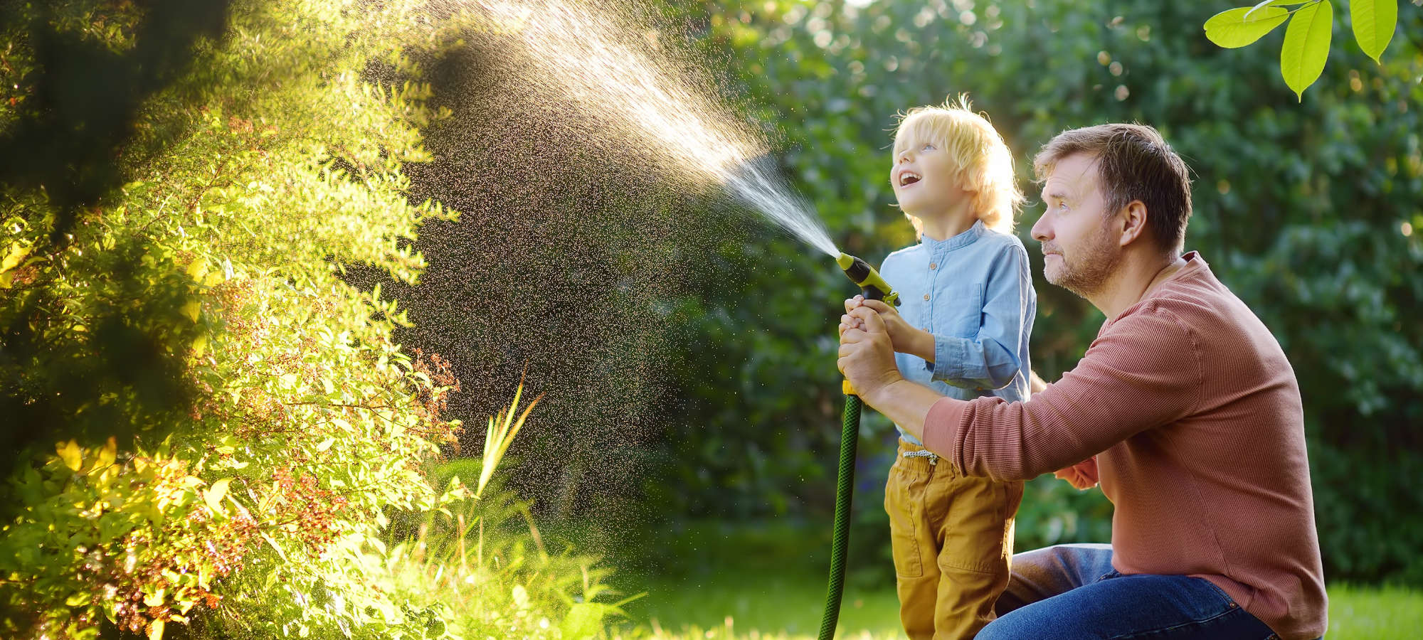 Man and son playing in garden ignoring neighbours alarm going off